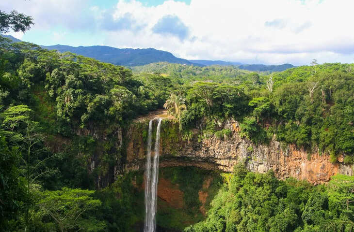 जब भी हम मॉरीशस का नाम सुनते हैं तो हमारे मन में खूबसूरत समुद्रतट, साफ नीला पानी और हरे-भरे पहाड़ों की छवि उभरती है। मॉरीशस दुनिया के सबसे आकर्षक पर्यटन स्थलों में से एक है, जहां हर साल लाखों पर्यटक आते हैं। यह आमतौर पर एक रोमांटिक गंतव्य के रूप में जाना जाता है, लेकिन मॉरीशस में न केवल समुद्र तट हैं, बल्कि कई छिपे हुए अनोखे स्थान भी हैं जिनके बारे में बहुत कम पर्यटक जानते हैं।   अगर आप भीड़-भाड़ वाली जगहों से दूर कुछ नया तलाशना चाहते हैं और मॉरीशस की असली खूबसूरती देखना चाहते हैं तो आपको यहां की छिपी हुई जगहों पर जरूर जाना चाहिए। ये स्थान आपको शांति, रोमांच और प्रकृति के करीब होने का अनूठा अनुभव देंगे। तो चलिए जानते हैं मॉरीशस की 5 खूबसूरत छिपी हुई जगहें, जहां आपको जरूर जाना चाहिए।  1. ग्रिस ग्रिस बीच यदि आप मॉरीशस के प्रसिद्ध समुद्र तटों की भीड़ से दूर एक शांत जगह की तलाश में हैं, तो ग्रिस ग्रिस बीच आपके लिए एकदम सही जगह है। यह समुद्र तट मॉरीशस के दक्षिणी भाग में स्थित है और यहाँ का दृश्य किसी स्वर्ग से कम नहीं है। इस समुद्र तट के बारे में बहुत कम लोग जानते हैं इसलिए यहां भीड़ कम होती है। यह स्थान सूर्यास्त देखने के लिए आदर्श माना जाता है।  2. रोचेस्टर फॉल्स यदि आप मॉरीशस के हरे-भरे प्राकृतिक स्थलों की सैर करना चाहते हैं, तो रोचेस्टर फॉल्स की यात्रा करें। यह झरना अपनी अनोखी चट्टानों और साफ़ पानी के लिए प्रसिद्ध है। यह मॉरीशस के सबसे बड़े और सबसे खूबसूरत झरनों में से एक है। यहां आप झरने के नीचे नहाने का आनंद ले सकते हैं। यह साहसिक प्रेमियों और फोटोग्राफरों के लिए भी एक आदर्श स्थान है।   3. ले मोर्ने ब्रैबेंट अगर आप ट्रैकिंग और रोमांच के शौकीन हैं तो ले मोर्ने ब्रेबेंट हिल आपके लिए बेहतरीन जगह है। यह मॉरीशस के सबसे ऊंचे और ऐतिहासिक पर्वतों में से एक है, जो यूनेस्को विश्व धरोहर स्थल में शामिल है। ट्रैकिंग का आनंद लेने के लिए यह एक बेहतरीन जगह है। इस पर्वत की चोटी से मॉरीशस का शानदार दृश्य देखा जा सकता है। यदि आप साहसिक और प्रकृति प्रेमी हैं तो यह स्थान आपके लिए एक आदर्श स्थान साबित हो सकता है।  4. चामरेल सात रंग की धरती यदि आप मॉरीशस में कुछ अलग और अनोखा देखना चाहते हैं, तो चामरेल सेवन कलर्ड अर्थ पर जाएँ। यह एक ऐसी जगह है जहाँ आपको मिट्टी के सात अलग-अलग रंग देखने को मिलेंगे। सूर्यास्त और सूर्योदय के समय यह स्थान बहुत सुन्दर दिखता है। इसके अलावा आसपास के घने जंगल और हरियाली इस जगह को और भी आकर्षक बनाते हैं।
