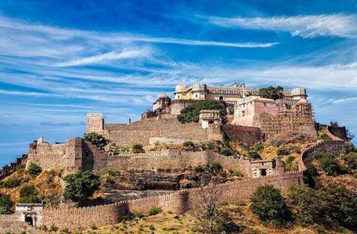 राजस्थान के राजसमंद जिले में अरावली की पहाड़ियों के बीच स्थित कुंभलगढ़ किला मेवाड़ की गौरवशाली विरासत का प्रतीक है। विशाल पत्थर की दीवारों, ऊंची पहाड़ियों और मजबूत सुरक्षा व्यवस्था के कारण इसे राजस्थान के सबसे महत्वपूर्ण दुर्गों में गिना जाता है। यह किला न केवल अपनी स्थापत्य कला के लिए प्रसिद्ध है, बल्कि मेवाड़ के इतिहास और महाराणा प्रताप से भी इसका गहरा संबंध है।  महाराणा कुंभा ने करवाया था निर्माण  कुंभलगढ़ किले का वर्तमान स्वरूप 15वीं शताब्दी में मेवाड़ के शासक महाराणा कुंभा के शासनकाल में विकसित हुआ। इतिहासकारों के अनुसार किले के निर्माण और विस्तार का कार्य लगभग 1443 से 1458 के बीच हुआ। किले का निर्माण अरावली की ऊंची पहाड़ी पर करवाया गया, जिससे यह प्राकृतिक रूप से भी बेहद सुरक्षित था।  महाराणा कुंभा ने मेवाड़ की सुरक्षा मजबूत करने के लिए कई दुर्गों का निर्माण और पुनर्निर्माण कराया था। कुंभलगढ़ इनमें सबसे महत्वपूर्ण दुर्गों में शामिल था।  36 किलोमीटर लंबी दीवार  कुंभलगढ़ की सबसे बड़ी खासियत इसकी विशाल परकोटे की दीवार है। इसे अक्सर करीब 36 किलोमीटर लंबी दीवार के रूप में वर्णित किया जाता है। इसकी चौड़ाई कई स्थानों पर इतनी अधिक है कि लोकप्रचलित रूप से कहा जाता है कि इस पर कई घोड़े एक साथ चल सकते हैं।  यह विशाल दीवार किले की प्राकृतिक पहाड़ी सुरक्षा के साथ मिलकर इसे बेहद मजबूत बनाती थी।  महाराणा प्रताप का जन्म यहीं हुआ  कुंभलगढ़ का इतिहास महाराणा प्रताप से भी जुड़ा हुआ है। माना जाता है कि महाराणा प्रताप का जन्म 1540 में कुंभलगढ़ में हुआ था। इसलिए यह दुर्ग मेवाड़ के इतिहास में विशेष स्थान रखता है।  महाराणा प्रताप ने मुगल सम्राट अकबर के विरुद्ध मेवाड़ की स्वतंत्रता के लिए संघर्ष किया। हल्दीघाटी का युद्ध और उसके बाद का संघर्ष राजस्थान के इतिहास की महत्वपूर्ण घटनाओं में गिना जाता है।  किले के अंदर कई मंदिर  कुंभलगढ़ केवल सैन्य दृष्टि से महत्वपूर्ण दुर्ग नहीं था। इसके परिसर में अनेक मंदिर भी स्थित हैं। इनमें हिंदू और जैन परंपरा से जुड़े मंदिर शामिल हैं। नीलकंठ महादेव मंदिर किले के प्रमुख धार्मिक स्थलों में से एक है।  किले के भीतर महल, मंदिर, बावड़ियां और अन्य ऐतिहासिक संरचनाएं इसकी विशालता और तत्कालीन स्थापत्य कौशल को दर्शाती हैं।  दुश्मनों के लिए जीतना आसान नहीं था  कुंभलगढ़ को मेवाड़ की सुरक्षा व्यवस्था में रणनीतिक रूप से महत्वपूर्ण माना जाता था। ऊंची पहाड़ियों पर स्थित होने और मजबूत दीवारों के कारण इस दुर्ग तक पहुंचना और इसे जीतना बेहद कठिन था।  इतिहास में किले पर कई बार आक्रमण हुए। इसके बावजूद इसकी प्राकृतिक और सैन्य सुरक्षा ने इसे लंबे समय तक महत्वपूर्ण दुर्ग बनाए रखा।  विश्व धरोहर का हिस्सा  कुंभलगढ़ किला आज राजस्थान के प्रमुख पर्यटन स्थलों में शामिल है। यह यूनेस्को की विश्व धरोहर सूची में शामिल 'Hill Forts of Rajasthan' का हिस्सा है। इस समूह में राजस्थान के छह प्रमुख पहाड़ी किले शामिल हैं।  आज यहां देश-विदेश से पर्यटक किले की विशाल दीवार, महलों, मंदिरों और अरावली के शानदार दृश्यों को देखने पहुंचते हैं।
