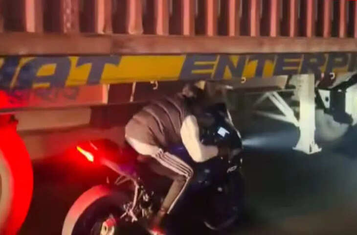 लाइक्स और व्यूज के लिए चलती ट्रक के नीचे बाइक लेकर पहुंचा बंदा, खतरनाक स्टंट रील हुई वायरल