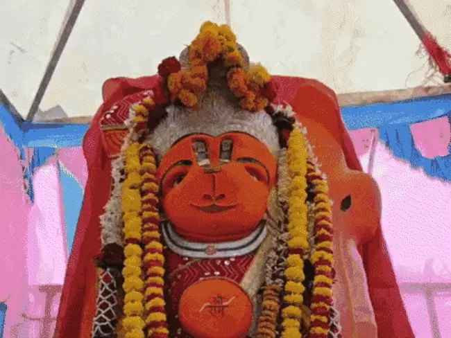 शहर के सती गेट के पास स्थित प्रसिद्ध खड़े हनुमान मंदिर को हटाने की कार्रवाई इन दिनों चर्चा का विषय बनी हुई है। मंदिर हटाने की प्रक्रिया से जुड़े कई वीडियो सोशल मीडिया पर तेजी से वायरल हो रहे हैं। इनमें प्रतिमा को हटाने के प्रयास और उसके नहीं हिलने की बातें सामने आ रही हैं।  सोशल मीडिया पर भक्तों के बीच यह दावा भी किया जा रहा है कि भगवान हनुमान की प्रतिमा चमत्कारिक रूप से अपनी जगह से नहीं हिली। हालांकि प्रशासनिक स्तर पर पूरे मामले की तकनीकी जांच कराई जा रही है।  सड़क चौड़ीकरण के लिए हटाने की कार्रवाई  जानकारी के अनुसार, उज्जैन में सड़क चौड़ीकरण कार्य के तहत सती गेट क्षेत्र में स्थित खड़े हनुमान मंदिर के ढांचे को हटाने की कार्रवाई शुरू की गई थी।  प्रशासन की टीम ने जेसीबी और अन्य मशीनों की मदद से मंदिर परिसर को हटाने का प्रयास किया, लेकिन प्रतिमा को हटाने में सफलता नहीं मिली।  प्रतिमा की गहराई की जांच कर रहे विशेषज्ञ  लगातार प्रयास के बाद प्रशासन ने मामले की तकनीकी जांच के लिए विशेषज्ञों की मदद लेने का फैसला किया है। इसके तहत आईआईटी इंदौर की टीम को बुलाया गया।  विशेषज्ञों ने आधुनिक उपकरणों की मदद से प्रतिमा की गहराई और उसके आसपास की जमीन की स्थिति की जांच की है। टीम यह पता लगाने का प्रयास कर रही है कि प्रतिमा जमीन में कितनी गहराई तक स्थापित है और इसे सुरक्षित तरीके से हटाया जा सकता है या नहीं।  भक्त मान रहे हैं धार्मिक संकेत  खड़े हनुमान मंदिर से लोगों की गहरी आस्था जुड़ी हुई है। श्रद्धालु भगवान हनुमान की प्रतिमा को &lsquo;डॉक्टर हनुमान&rsquo; के नाम से भी जानते हैं।  स्थानीय मान्यता है कि यहां दर्शन और पूजा करने से बीमारियों और परेशानियों से राहत मिलती है। इसी वजह से प्रतिमा का नहीं हटना कई भक्तों के लिए आस्था और विश्वास का विषय बन गया है।  प्रशासन देगा विशेषज्ञ रिपोर्ट के आधार पर फैसला  अधिकारियों का कहना है कि प्रतिमा को लेकर कोई भी निर्णय विशेषज्ञों की रिपोर्ट के आधार पर लिया जाएगा। प्रशासन की प्राथमिकता प्रतिमा और धार्मिक भावनाओं का सम्मान करते हुए सुरक्षित प्रक्रिया अपनाना है।  फिलहाल मंदिर हटाने की कार्रवाई और विशेषज्ञों की जांच रिपोर्ट को लेकर लोगों की नजरें बनी हुई हैं। सोशल मीडिया पर वायरल हो रहे वीडियो के कारण यह मामला लगातार चर्चा में है।