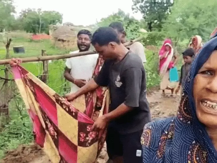 बारिश में कीचड़ बनी सड़क, बीमार बच्चे को खाट पर ले जाने को मजबूर हुए ग्रामीण