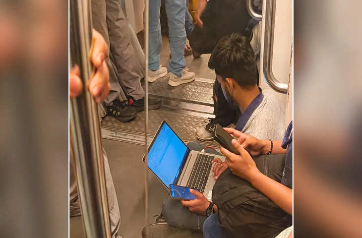 Delhi Metro में फर्श पर बैठकर लैपटॉप पर काम करता दिखा युवक, लोग बोले&mdash;ये डेडिकेशन है या शोषण?