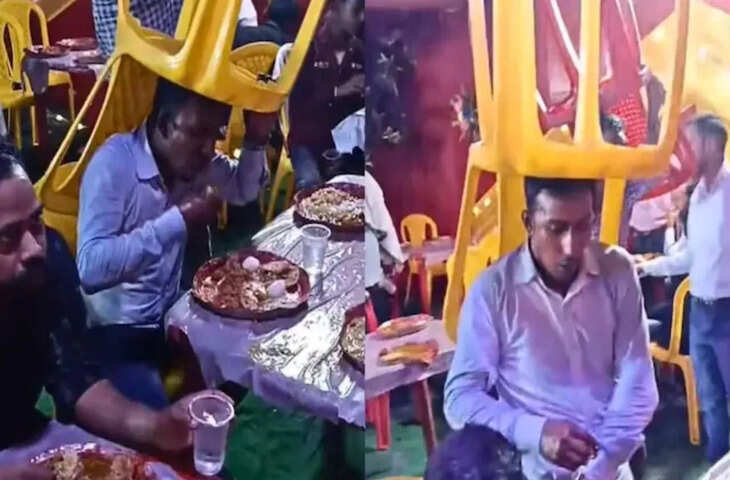 Viral Clip: आंधी-तूफान में भी जारी रही दावत, बारिश के बीच सिर पर कुर्सी रख खाना खाता दिखा शख्स